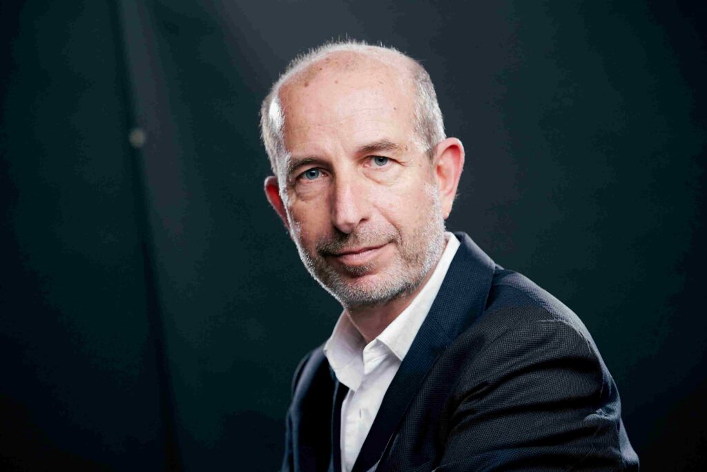 Jaume Sanpera CEO and co-founder of Sateliot in a suit against a dark background, representing leadership in satellite and IoT connectivity advancements.