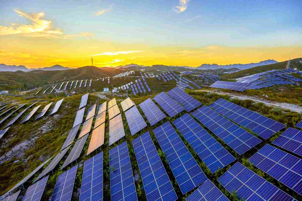 Solar panels installed in a remote, lush green area, blending harmoniously with the natural surroundings. IoT connectivity enhances energy efficiency and monitoring, showcasing a sustainable approach to harnessing renewable energy in off-grid locations.