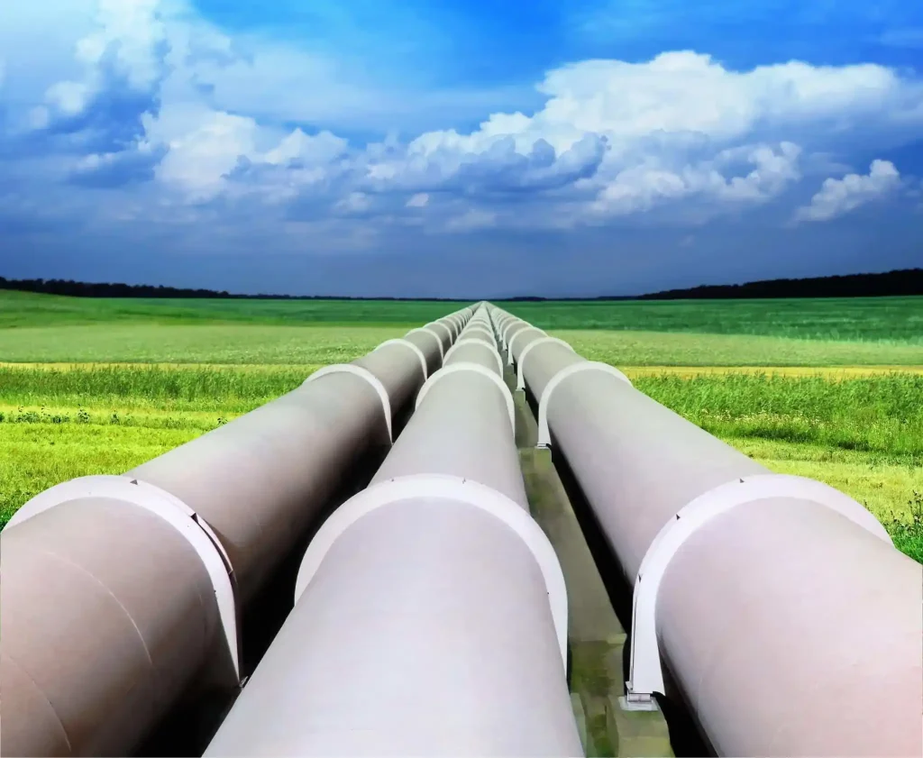 Three large oil pipelines extending across a lush grassy landscape, representing the critical infrastructure for energy transport. IoT connectivity enhances monitoring and maintenance, ensuring efficient and secure operations in remote areas.